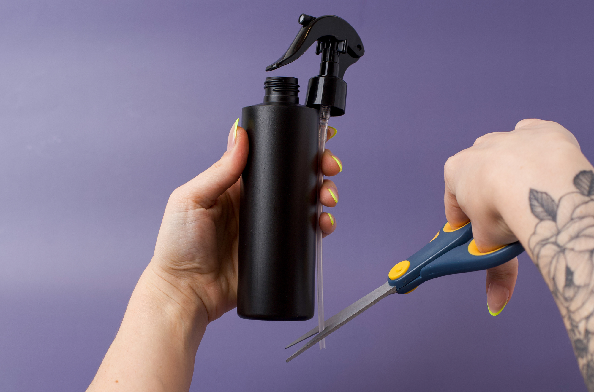 Using scissors to cut sprayer tube to the proper length for bottle.